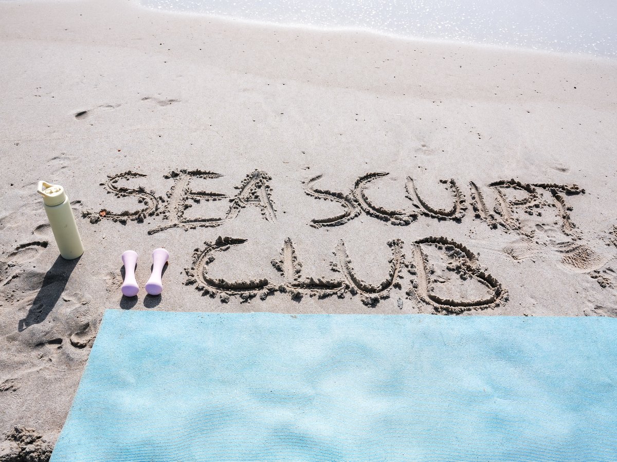 Sea Sculpt Club written in the sand