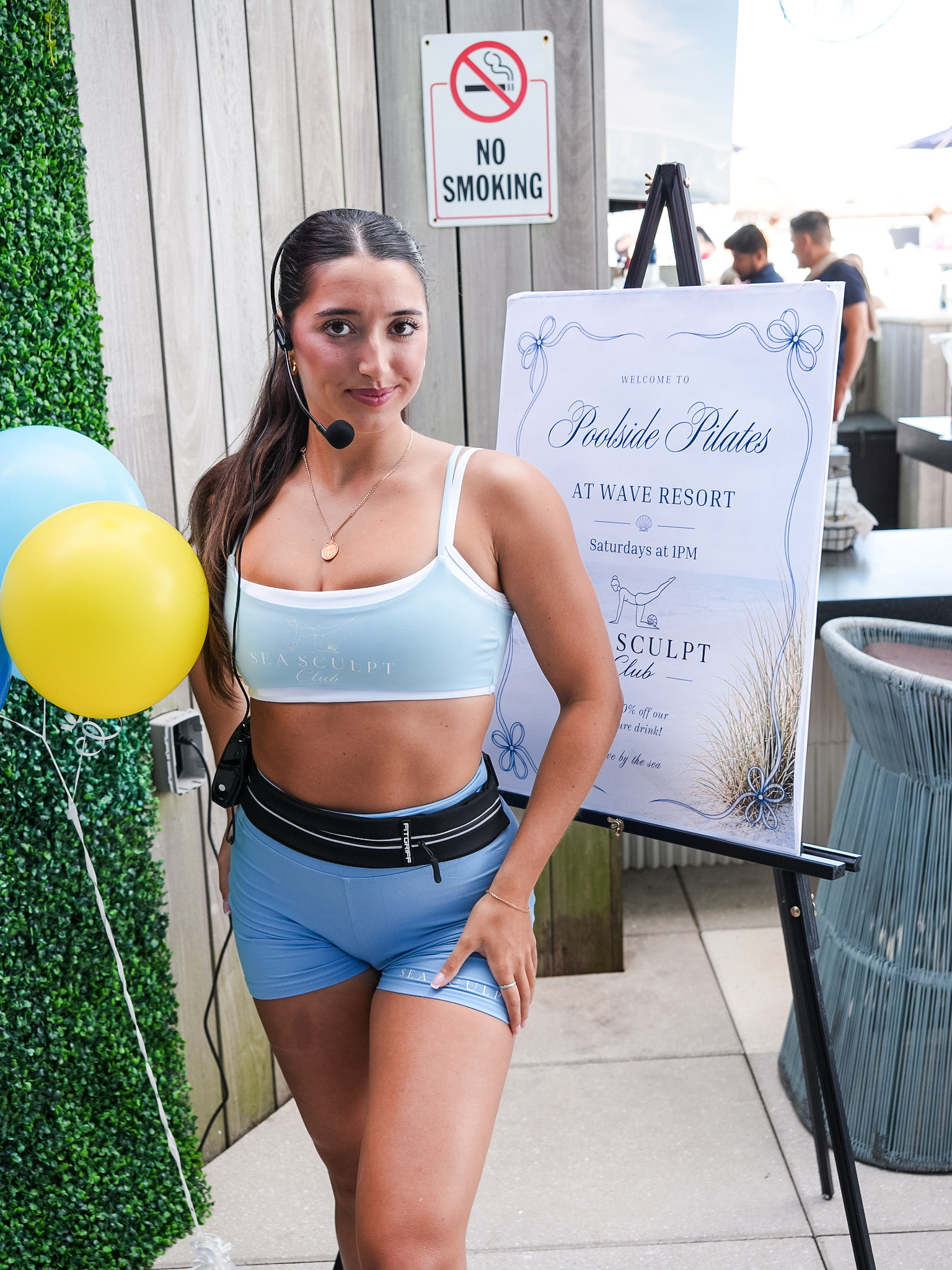 Sea Sculpt Club instructor with Poolside Pilates at Wave Resort welcome sign