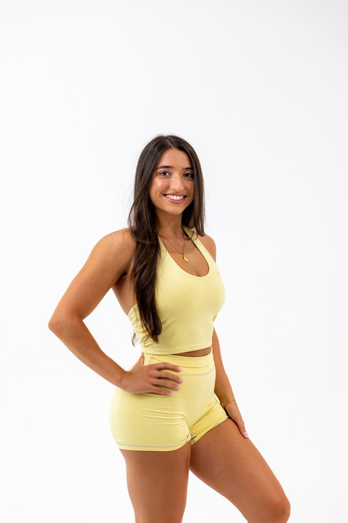 Amanda smiling in a yellow workout set