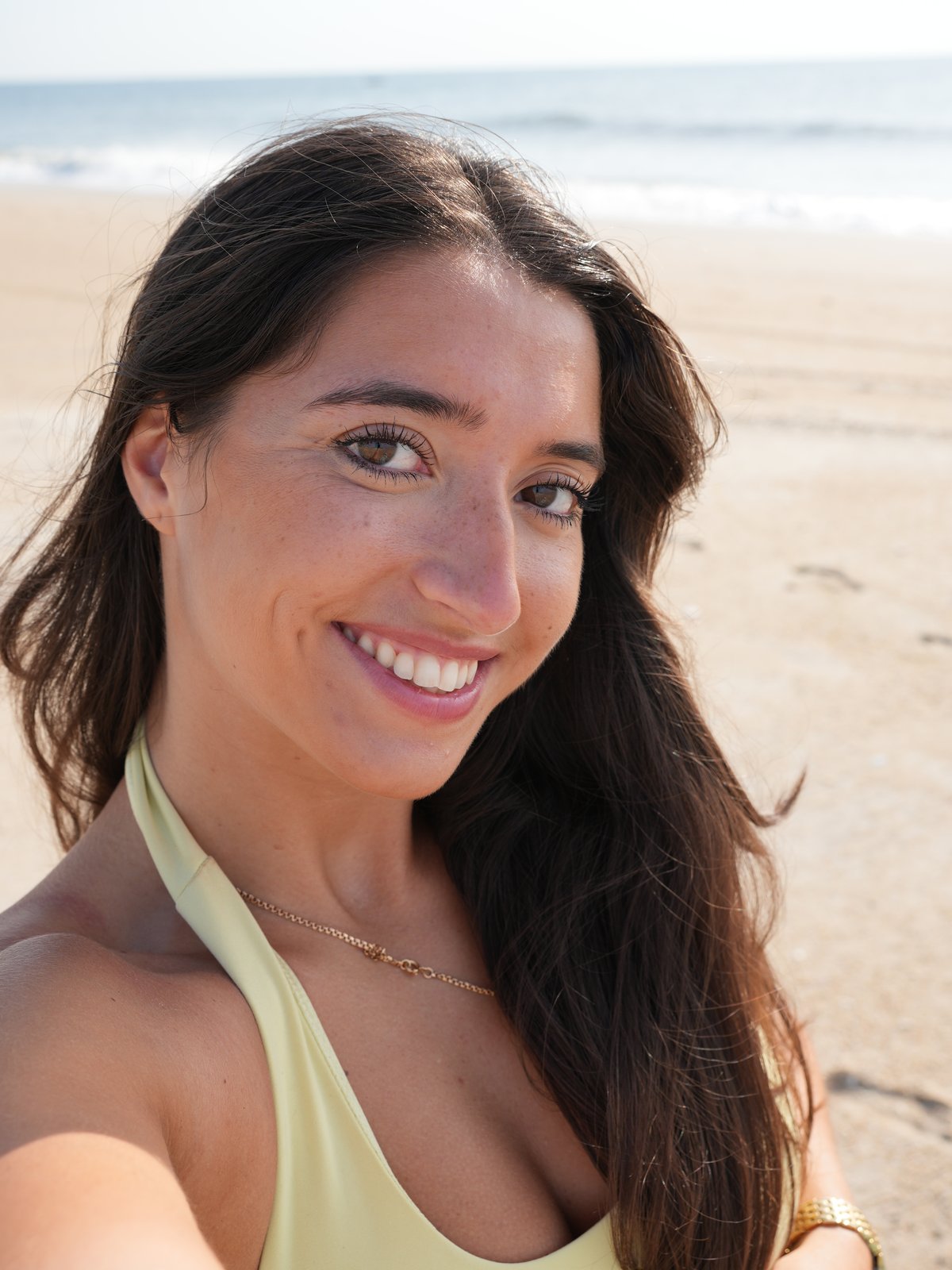 Amanda Cavadas, founder of Sea Sculpt Club, smiling on the beach