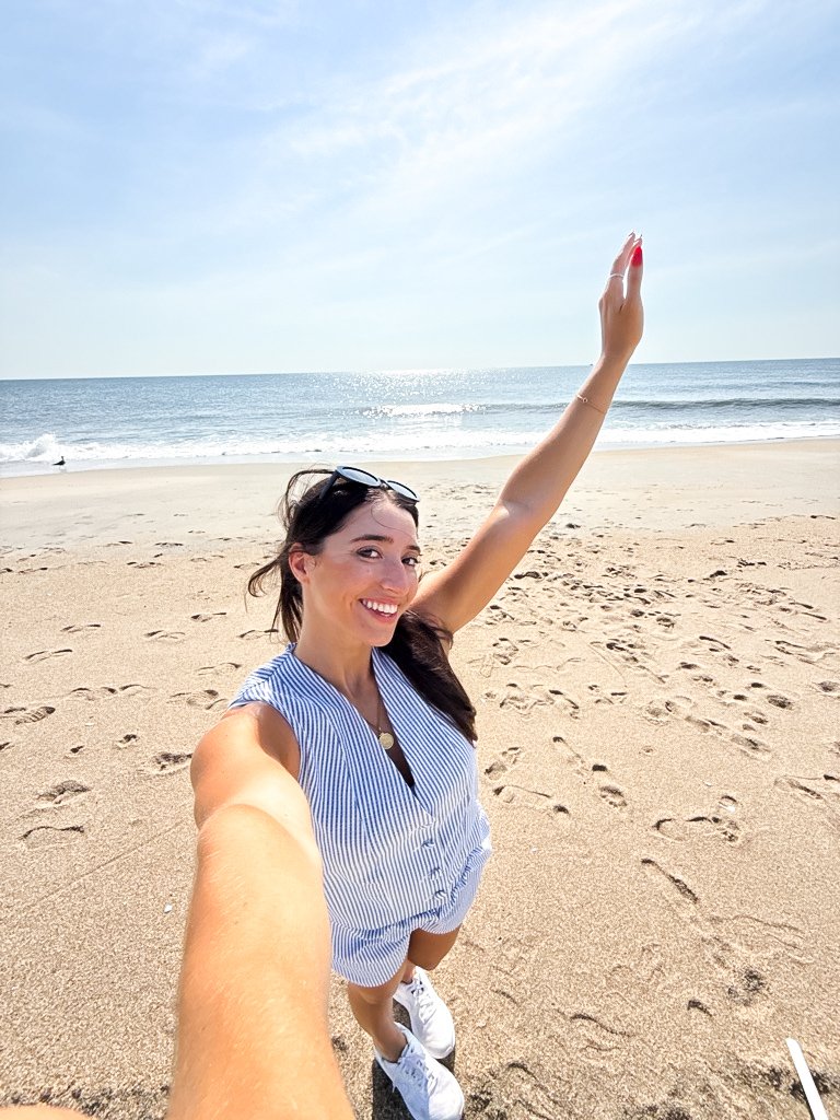 Amanda waving on the beach