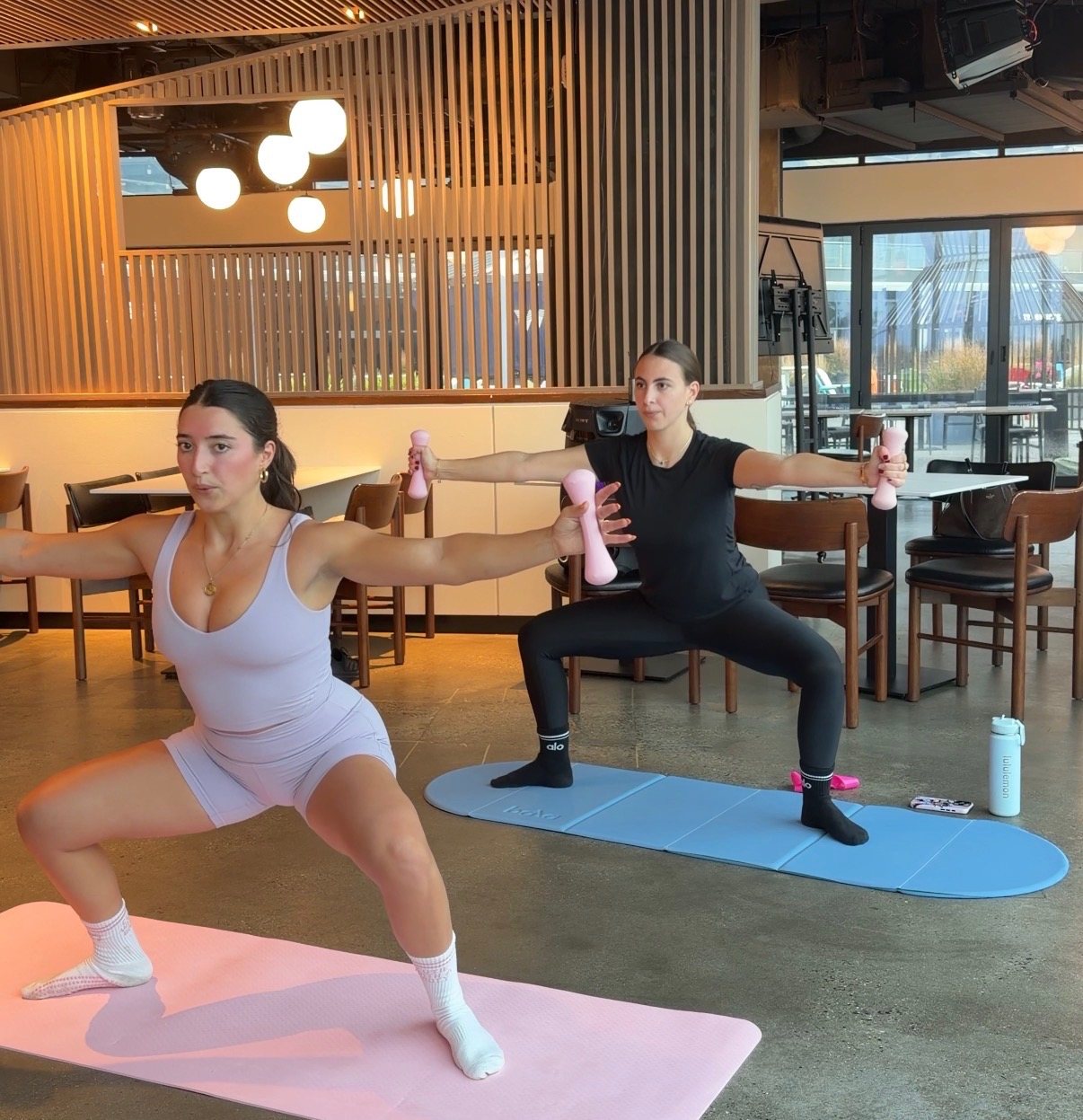 Amanda leading a one-on-one session with pink hand weights
